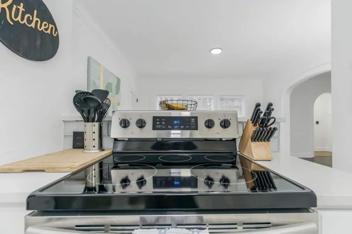A modern, welcoming kitchen equipped with a stove, kitchen utensils, and a knife block. The space radiates warmth and liveliness, inviting guests to cook, prepare meals, or host group dinners. The setup is ideal for self-catering, allowing teams to stock up on snacks or prepare shared meals.
