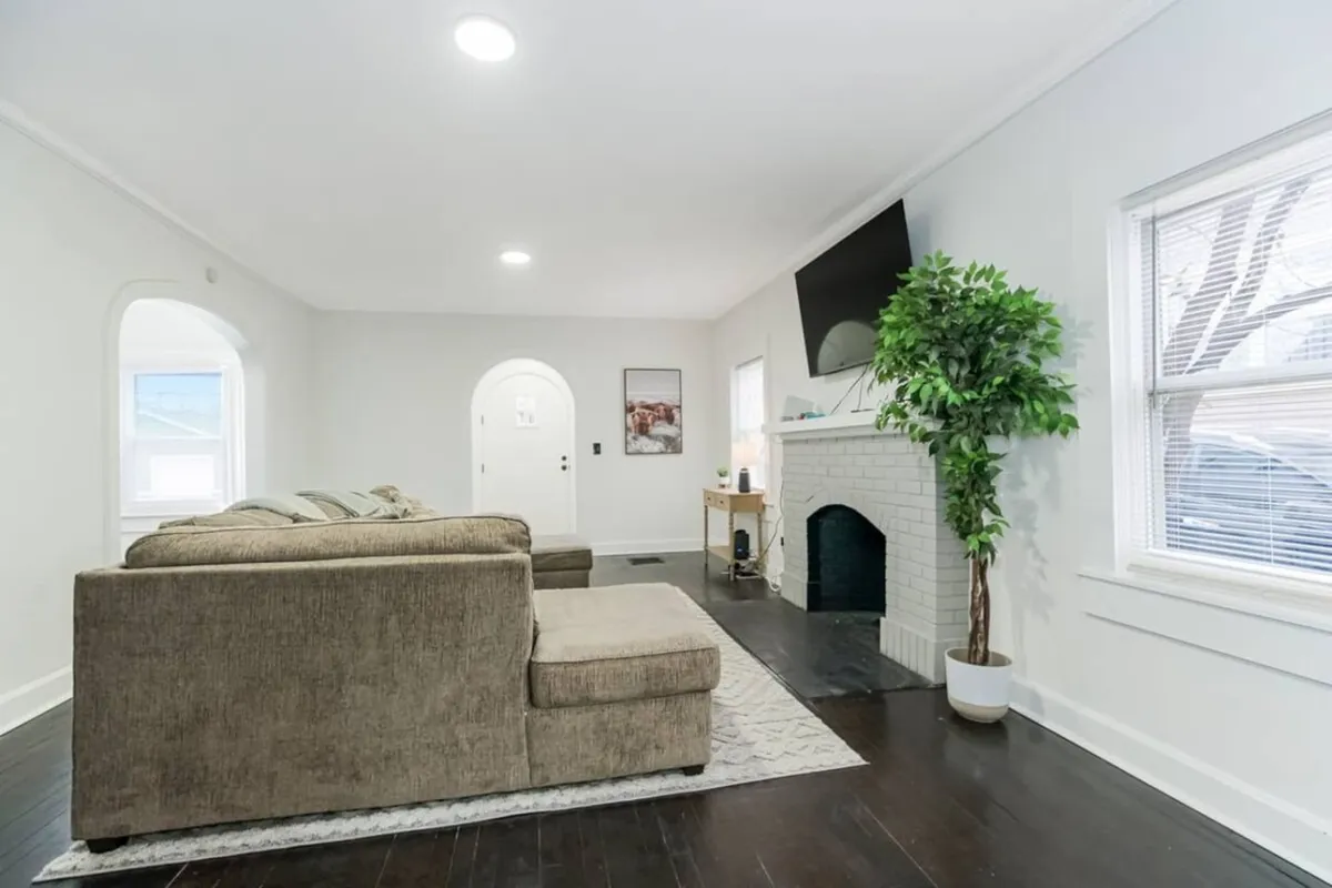 A comfortable living area featuring a sectional sofa, a modern fireplace, a television positioned for group viewing, and an indoor plant adding a fresh touch. The setup is designed for relaxation, conversation, and entertainment for groups of all sizes.